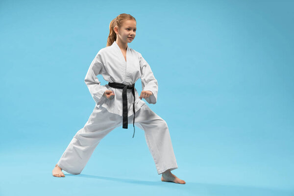 Girl performing defense position of karate.
