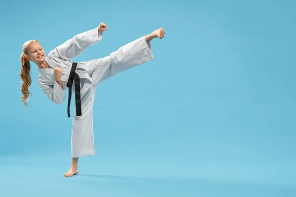 Positivo karatê menina praticando chute pé para a frente . — Fotografia de Stock