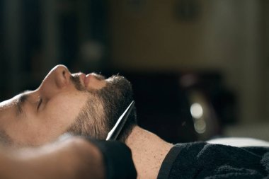 Modern berber dükkanında sakal bırakan adamın yan görünüşü