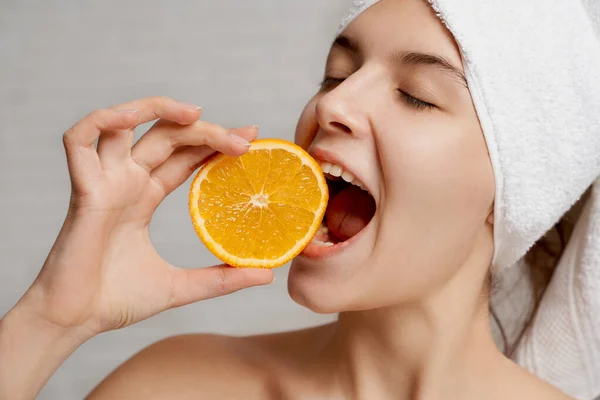 Fechar o modelo positve segurando laranja e mordendo . — Fotografia de Stock