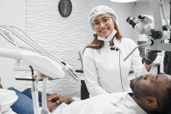 Dentista femenina posando mientras cura los dientes en la clínica — Foto de Stock