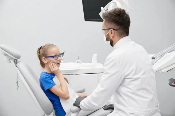 Menina reclamando de dor de dente no consultório odontológico — Fotografia de Stock