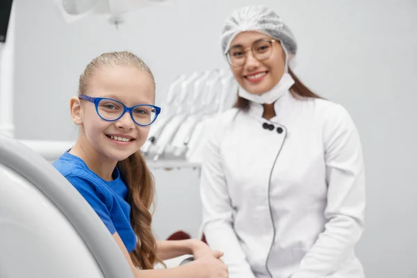 Paciente posando y sonriendo mientras está sentado en el consultorio del dentista — Foto de Stock