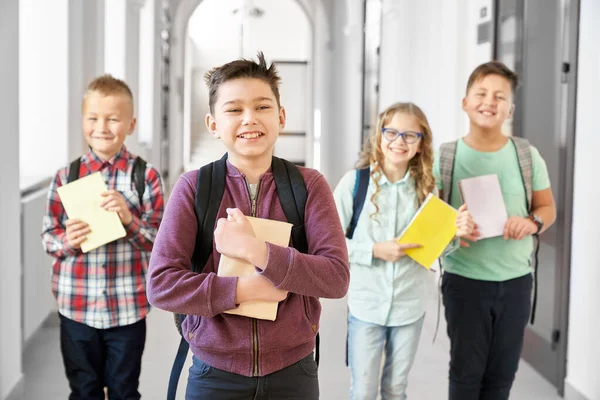 Escolar abrazando libro y sonriendo . — Foto de Stock