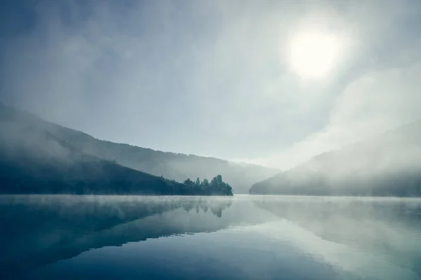 Foggy sunrise on lake.