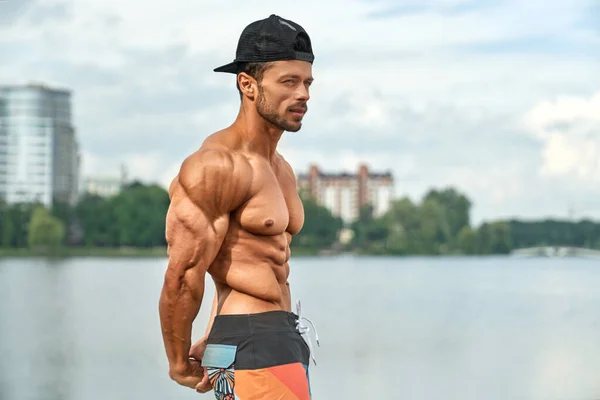 Hombre con cuerpo muscular perfecto posando al aire libre . — Foto de Stock