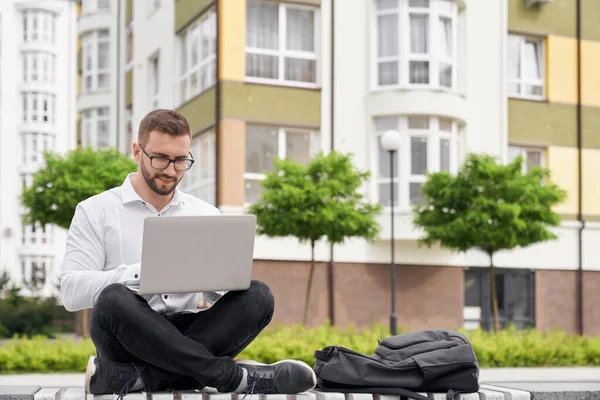 Freelancer trabalhando ao ar livre sentado no banco . — Fotografia de Stock