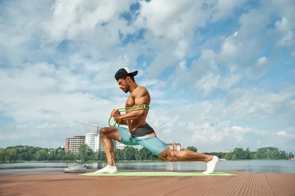 Esportista fazendo alongamento treino com expansor de borracha . Imagens Royalty-Free