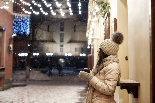 ผู้หญิงในเสื้อผ้าฤดูหนาวที่ถนนในตอนเย็น . — ภาพถ่ายสต็อก