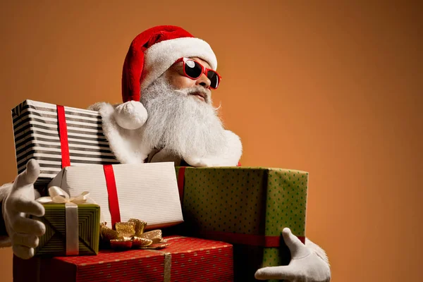 Cool Santa Claus w okularach przeciwsłonecznych gospodarstwa kolorowe pudełka — Zdjęcie stockowe