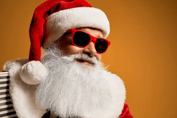 Portret starszego Mikołaja w czerwonych okularach przeciwsłonecznych w studio — Zdjęcie stockowe