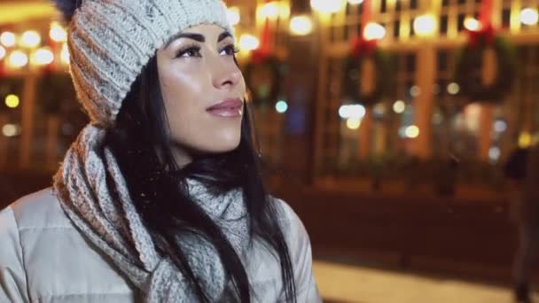 Meisje kijkt omhoog in de avondlucht op straat in de winter. — Stockvideo