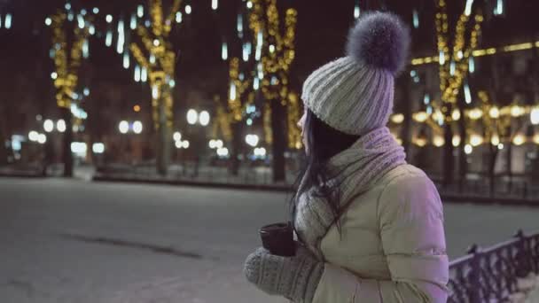 Model in warm clothing with coffee cup on square. — Stock Video