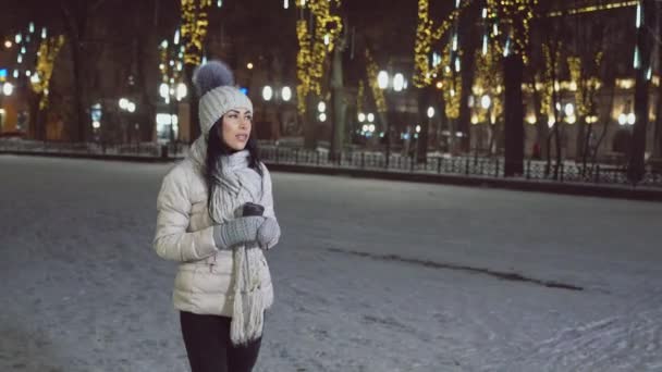Κορίτσι με χειμερινά ρούχα περπατώντας και πίνοντας καφέ. — Αρχείο Βίντεο