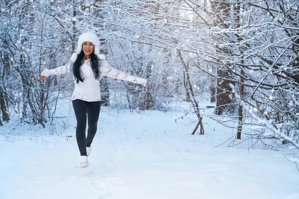 ผู้หญิงเล่นในหมวกอบอุ่น เดินในป่าฤดูหนาว . — ภาพถ่ายสต็อก