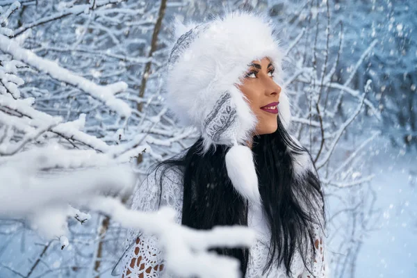 Modelo positivo posando entre galhos de árvores com neve . — Fotografia de Stock