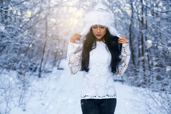 Menina de chapéu branco e blusa branca na floresta de inverno . — Fotografia de Stock