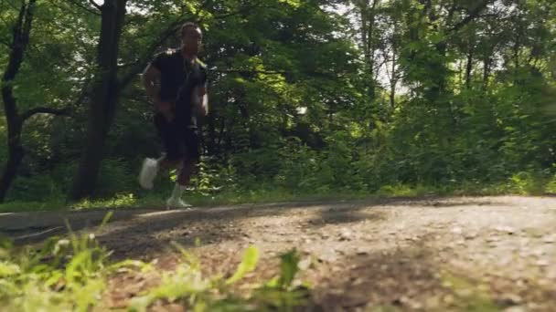 Mężczyzna afrykański biegacz pochylając się na kolanach zrobić przerwę na zewnątrz — Wideo stockowe