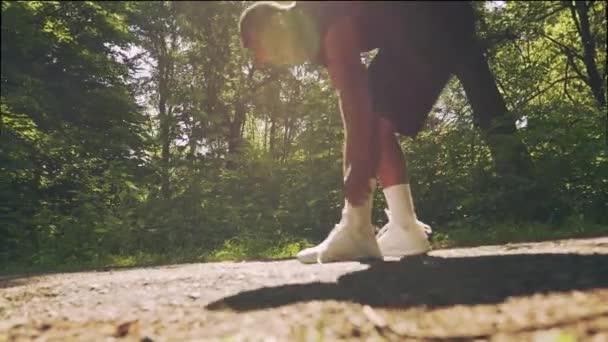 Afrikanischer Läufer bindet beim Morgentraining Schnürsenkel — Stockvideo