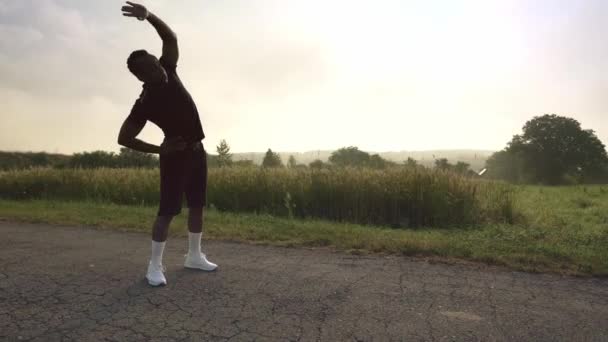 Afro samec běžec dělá strečink cvičení před cvičením — Stock video