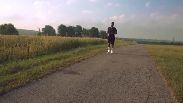 Actif afro guy en noir vêtements de sport faire cardio sur la nature — Video