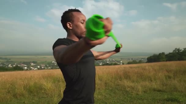 Vue latérale de l'homme africain travaillant avec un expanseur en caoutchouc — Video