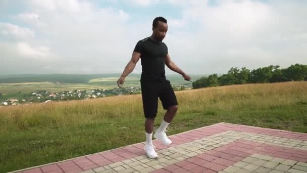 Athletic afro amerykański człowiek skacze na linie na świeżym powietrzu — Wideo stockowe