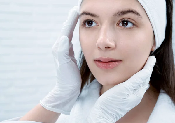 Close-up de morena com pele pura olhando para o médico no salão de beleza — Fotografia de Stock