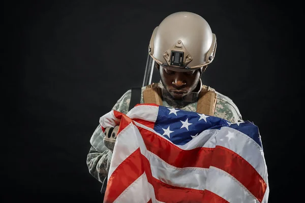 Soldado americano segurando bandeira nacional em mãos . — Fotografia de Stock