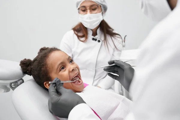Chica divertida acostada en la silla del dentista con la boca abierta — Foto de Stock