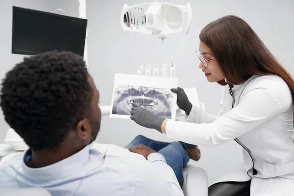 Dentiste féminine attrayante gardant l'image de rayons X des dents — Photo