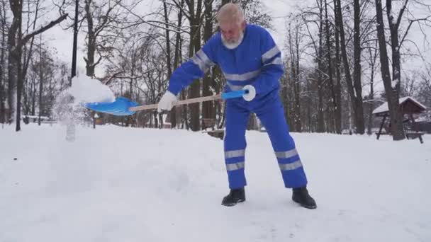 Senior čistič odstraňuje sníh. — Stock video