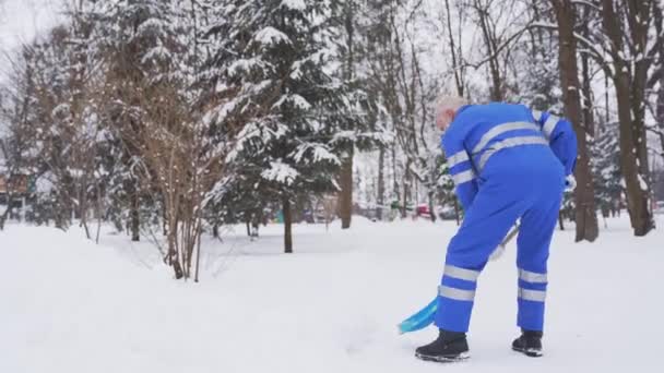 Limpiador senior quitando nieve en el parque . — Vídeos de Stock