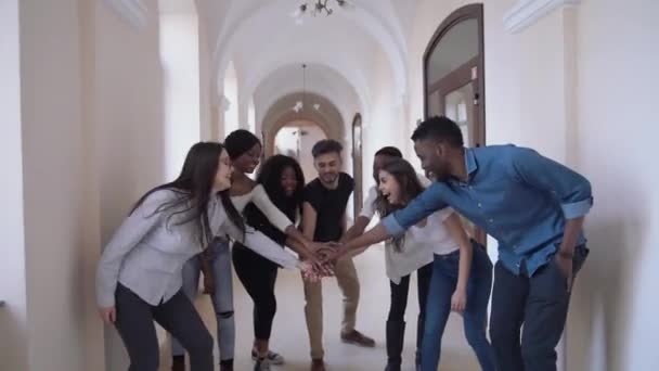 Estudantes felizes mostrando unidade unindo as mãos . — Vídeo de Stock