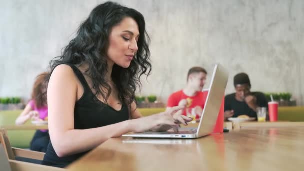 Leende kvinna med laptop i café. — Stockvideo