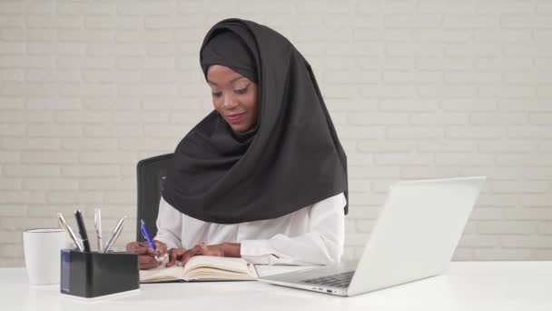 African woman writing in notebook. — Stock Video