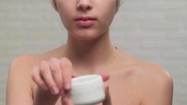 Donna in incognito in asciugamano mostrando crema . — Video Stock