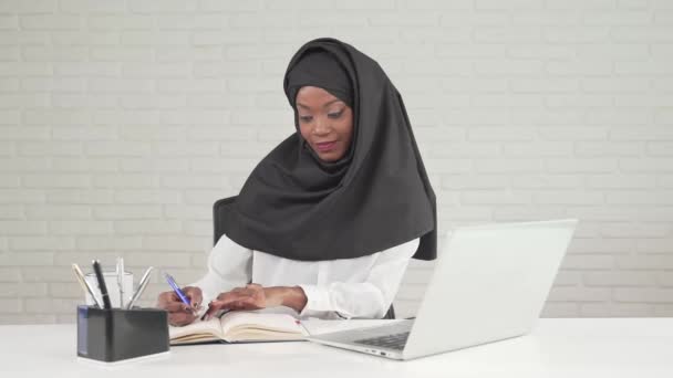 African woman writing in notebook. — Stock Video