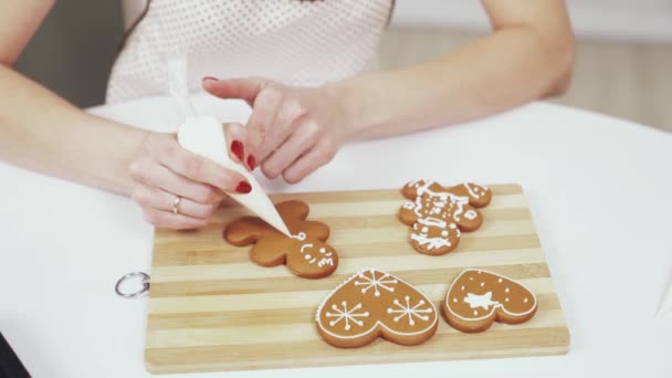 Married lady with red manicure painting cookies with glaze — Stock Video