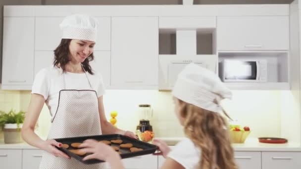 Çekici bir kadın ve küçük kızı bisküvi pişiriyor. — Stok video