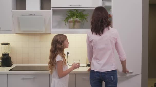 Vista posterior de la mujer vertiendo jugo en el vaso para la hija — Vídeos de Stock