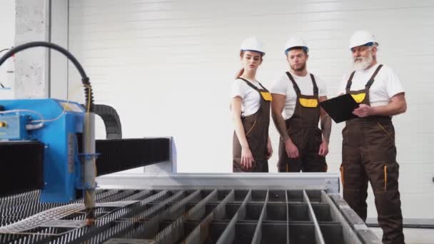 Három mérnök ellenőrzi a működő plazmavágót.. — Stock videók