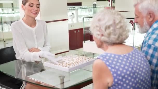 Joalheiro feminino ajudando casal idoso a escolher anéis de casamento — Vídeo de Stock