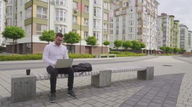 Dizüstü bilgisayar açık havada üzerinde çalışan genç serbest meslek.
