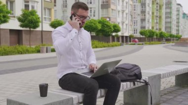 Dizüstü bilgisayar açık havada üzerinde çalışan genç serbest meslek.
