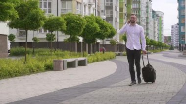 Bavullu sakallı adam akıllı telefondan konuşuyor..