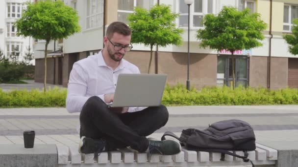 Freelancer barbudo usando laptop ao ar livre . — Vídeo de Stock