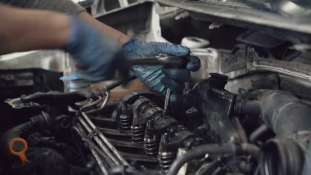 Car mechanic screwing spark plugs with spanner. — ストック動画