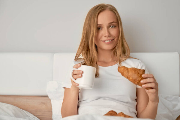 Girl enjoying breakfast in bed.