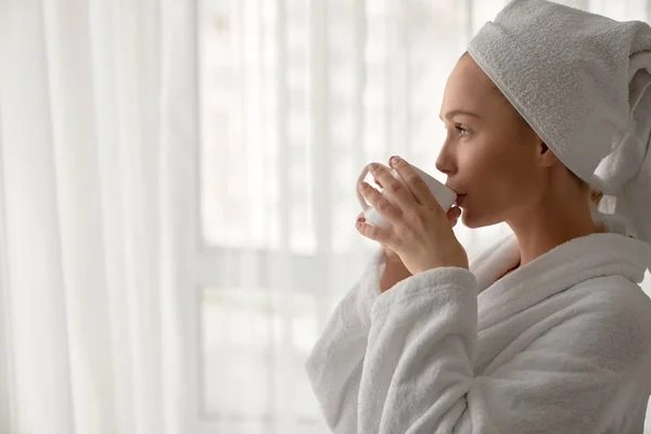 Girl in bathrobe drinking cup of coffee. — Stock Photo, Image